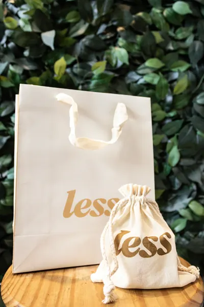 Sacola e saquinho de tecido com o logo da Less, para os produtos de autocuidado
